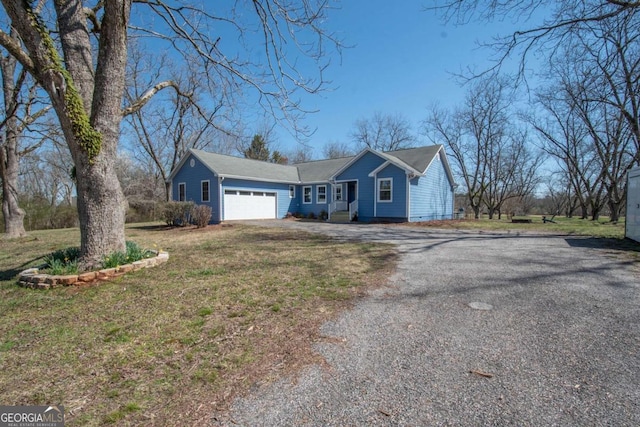 ranch-style home with driveway, an attached garage, and a front yard