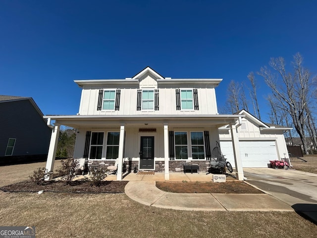 modern farmhouse style home featuring board and batten siding, concrete driveway, covered porch, a garage, and stone siding