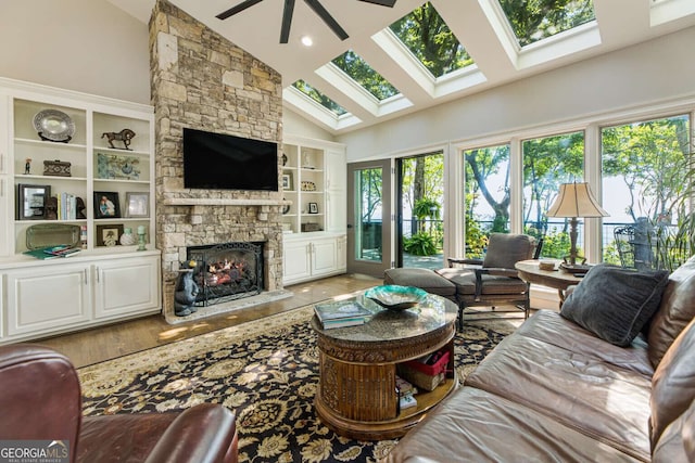 912 Mcelroy Mountain Dr, Big Canoe, GA 30143 - living room featuring a ceiling fan, high vaulted ceiling, a stone fireplace, a skylight, and wood finished floors