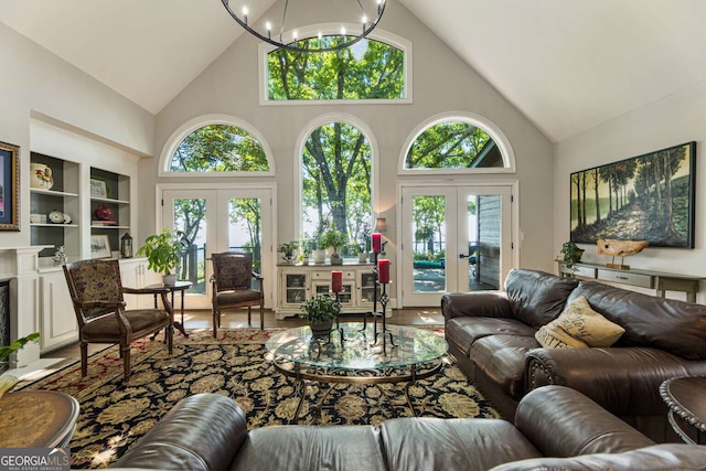 912 Mcelroy Mountain Dr, Big Canoe, GA 30143 - living area with french doors, high vaulted ceiling, a chandelier, built in shelves, and wood finished floors