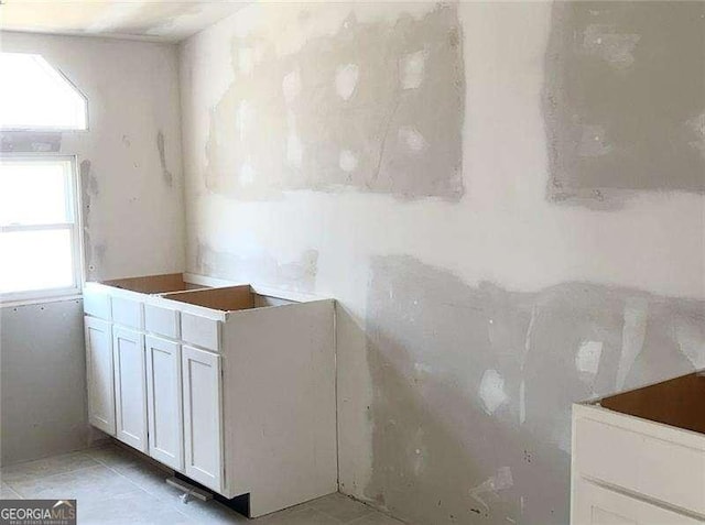 interior space with light tile patterned flooring and white cabinetry