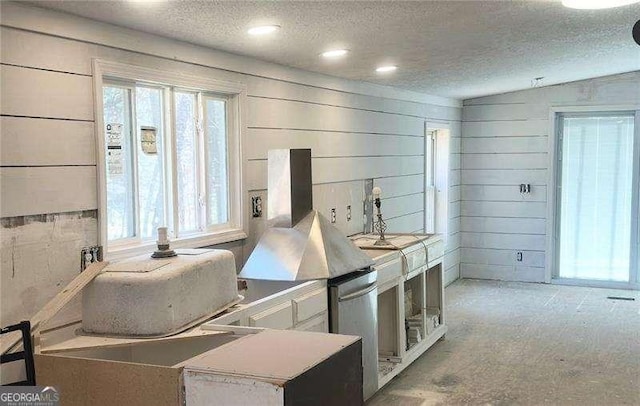 kitchen with a textured ceiling and white cabinetry