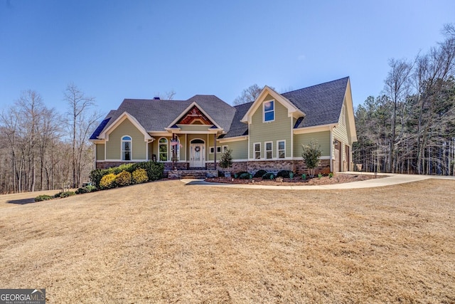 craftsman house with brick siding and a front yard