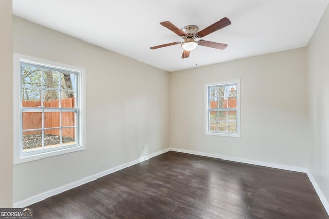 unfurnished room featuring baseboards, a ceiling fan, and dark wood-style flooring