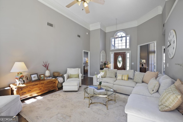 living area featuring visible vents, wood finished floors, and crown molding