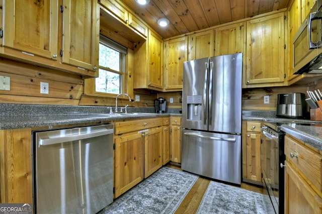 kitchen with dark countertops, wood ceiling, wood finished floors, stainless steel appliances, and a sink