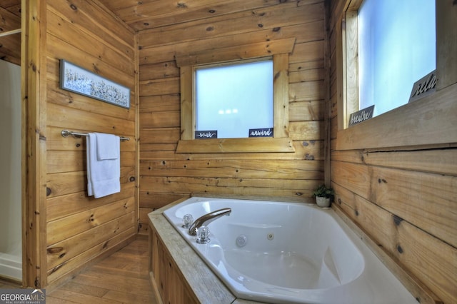 full bathroom featuring wooden walls, wood finished floors, and a whirlpool tub