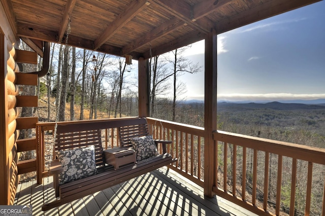 wooden terrace featuring a forest view and a mountain view