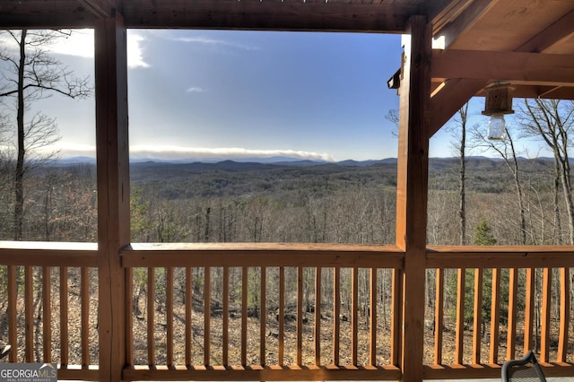 wooden deck featuring a forest view and a mountain view