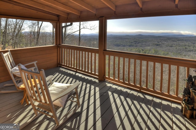 wooden deck with a mountain view and a view of trees