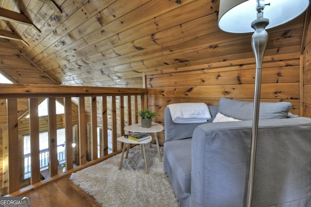 living area with wooden ceiling, wood finished floors, wood walls, and vaulted ceiling