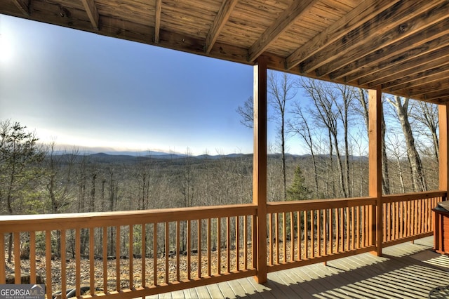 wooden deck with a mountain view and a wooded view