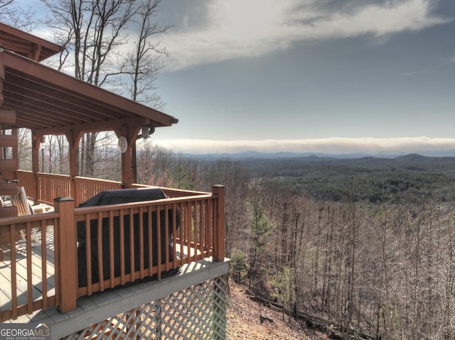 wooden terrace featuring a view of trees and a mountain view