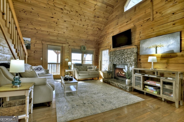 living room featuring wood walls, a fireplace, and hardwood / wood-style flooring