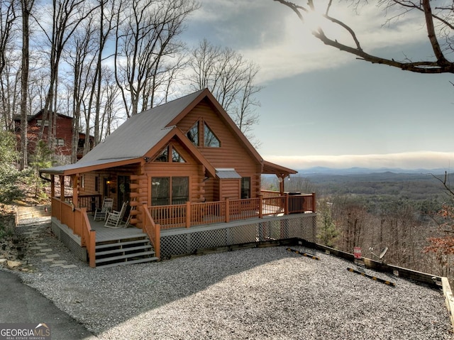 back of property featuring log siding and a deck with mountain view