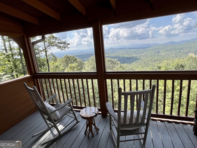 wooden terrace featuring a mountain view and a wooded view