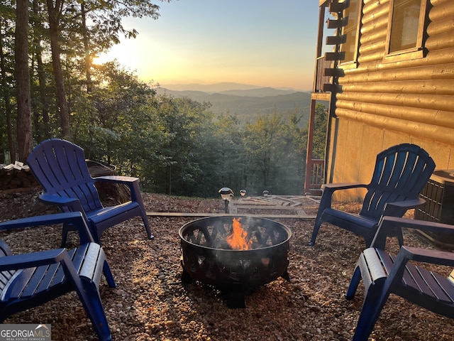 exterior space featuring a mountain view and an outdoor fire pit