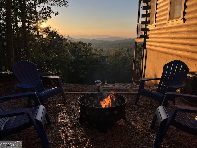 patio terrace at dusk with a mountain view and an outdoor fire pit