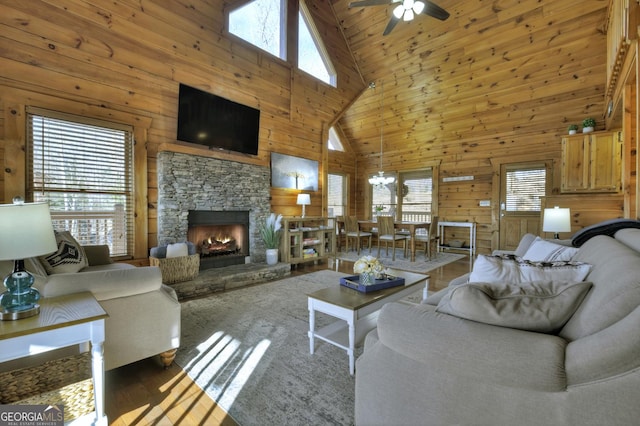 living room with plenty of natural light, wooden walls, and a fireplace