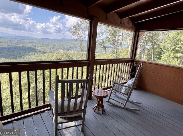 wooden terrace with a view of trees and a mountain view