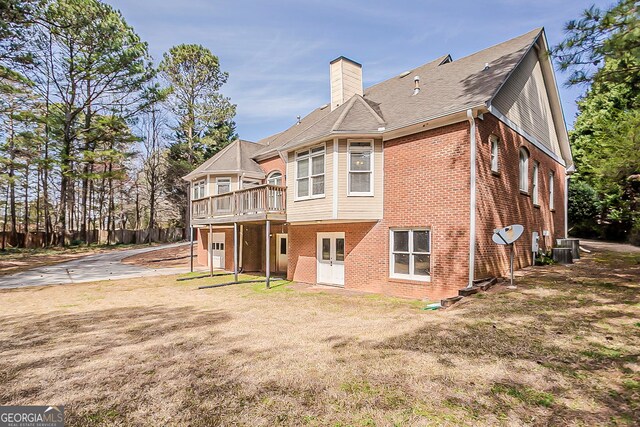 1621 Annapolis Way, Grayson, GA 30017 - back of house featuring central AC unit, a wooden deck, a yard, a chimney, and brick siding
