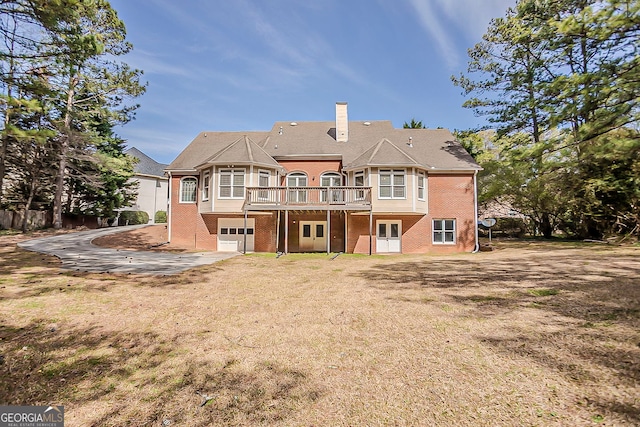 1621 Annapolis Way, Grayson, GA 30017 - back of property with driveway, a yard, an attached garage, a chimney, and brick siding