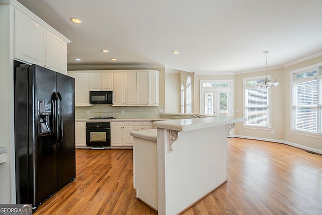 1621 Annapolis Way, Grayson, GA 30017 - kitchen featuring black appliances, backsplash, a peninsula, a breakfast bar area, and crown molding