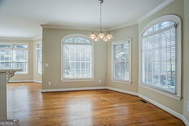 1621 Annapolis Way, Grayson, GA 30017 - unfurnished dining area with wood finished floors, visible vents, baseboards, crown molding, and a notable chandelier