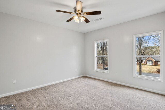 unfurnished room featuring baseboards, visible vents, a wealth of natural light, and carpet floors