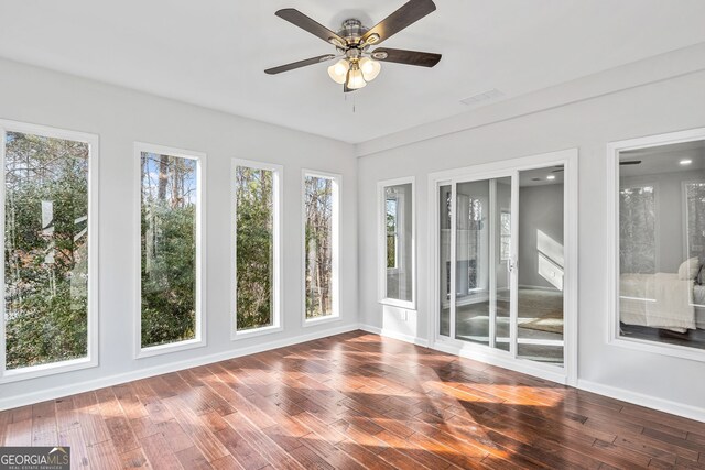 unfurnished sunroom with visible vents, plenty of natural light, and ceiling fan