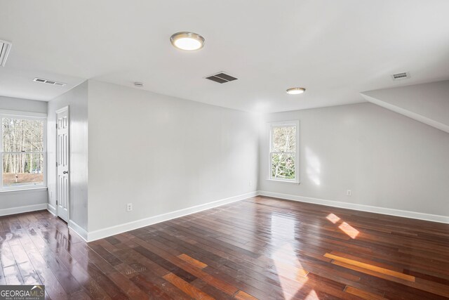 spare room with dark wood-style floors and visible vents