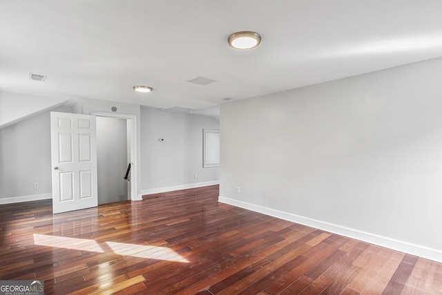 empty room with visible vents, baseboards, and hardwood / wood-style floors