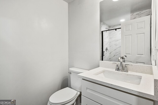 bathroom with a shower, toilet, and vanity