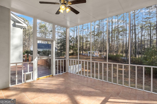 unfurnished sunroom featuring a ceiling fan