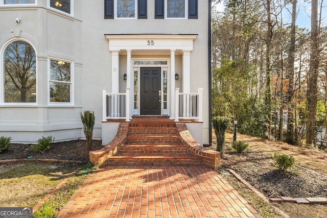 entrance to property featuring stucco siding