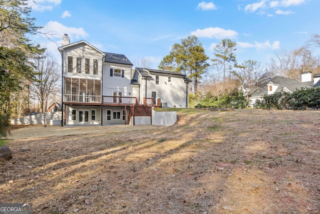 back of house with french doors, a deck, a chimney, and a sunroom