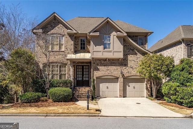 view of front of property featuring brick siding, a shingled roof, concrete driveway, french doors, and a garage