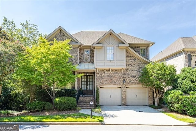 view of front of house with french doors, driveway, brick siding, and an attached garage