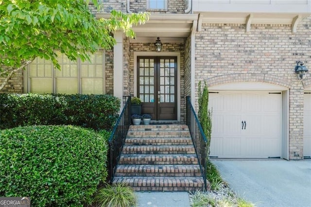 doorway to property with french doors, driveway, and a garage