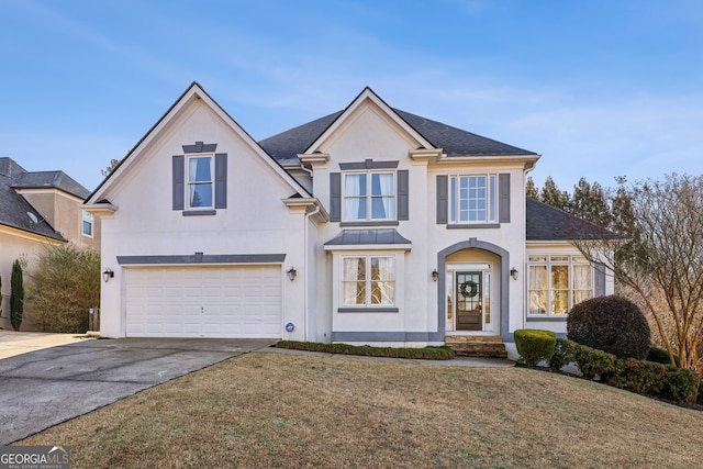 traditional-style house with stucco siding, a shingled roof, concrete driveway, a front yard, and an attached garage