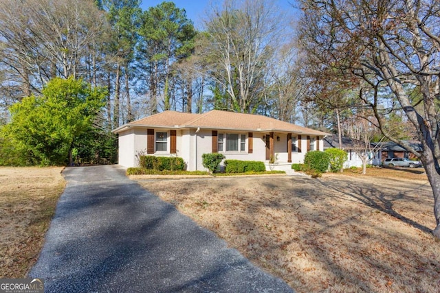 single story home with aphalt driveway and stucco siding