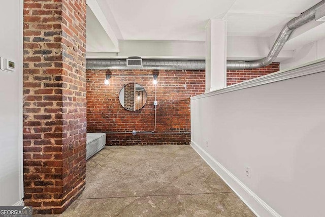 interior space with visible vents and brick wall