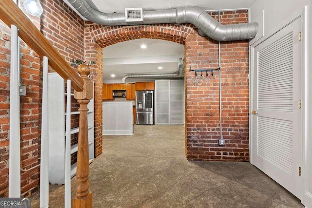 hallway with visible vents and brick wall