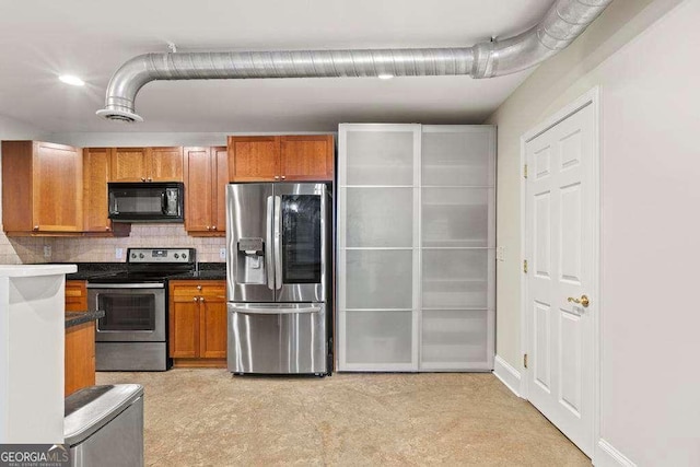 kitchen with dark countertops, backsplash, stainless steel appliances, and brown cabinetry