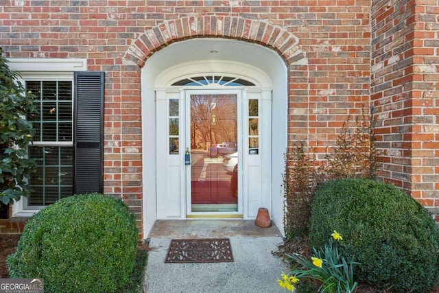 view of exterior entry featuring brick siding