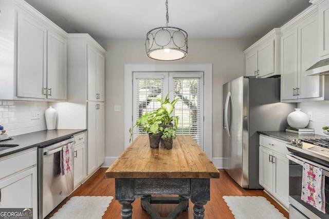 kitchen featuring decorative backsplash, stainless steel appliances, and dark wood-style flooring