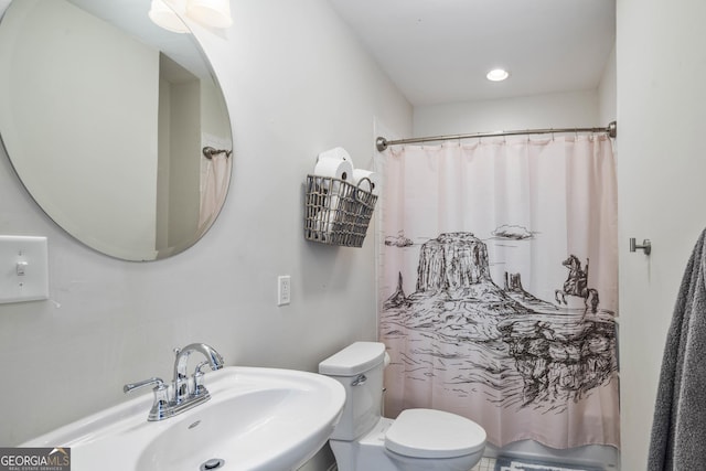 bathroom with toilet, a shower with shower curtain, and a sink