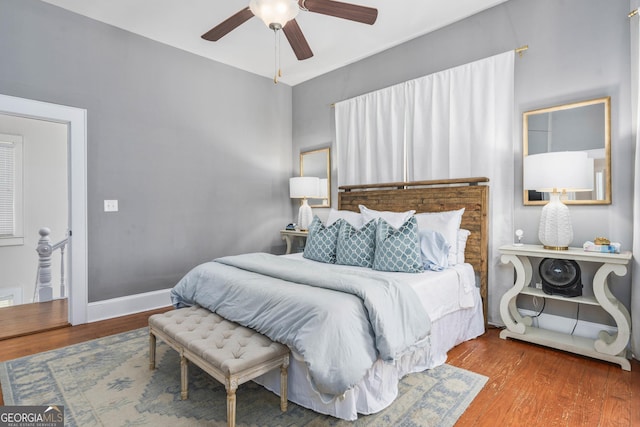 bedroom with ceiling fan, baseboards, and wood finished floors