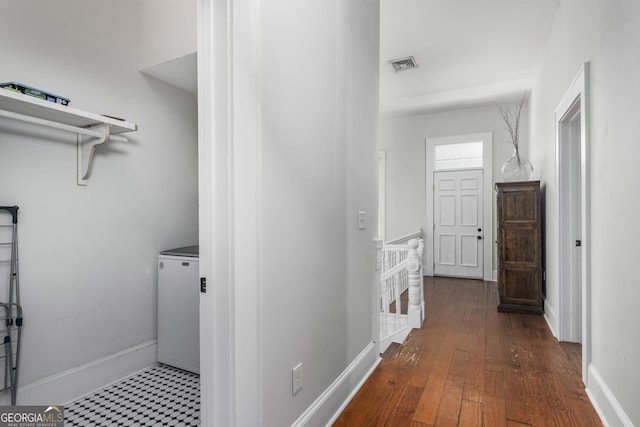 laundry area with laundry area, baseboards, visible vents, and wood-type flooring