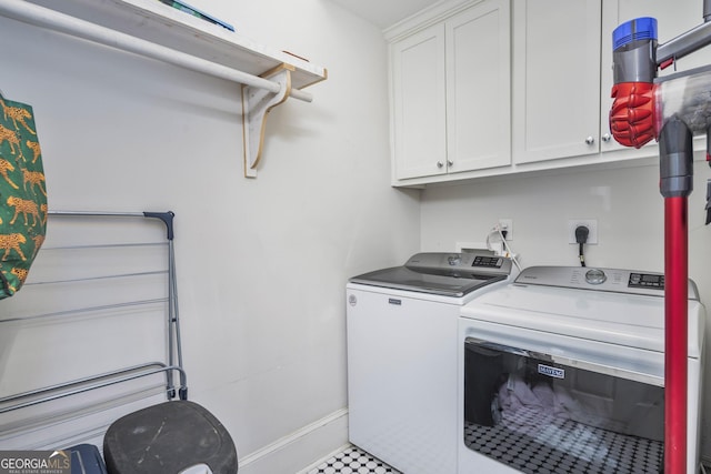 washroom featuring baseboards, cabinet space, and washing machine and dryer